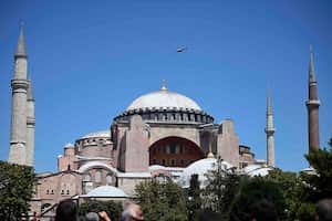 Un helicóptero policial sobrevuela la Hagia Sophia de la época bizantina, durante las oraciones del viernes. Miles de fieles musulmanes rodearon el monumento emblemático de Estambul para participar en las primeras oraciones en 86 años en la estructura que una vez fue la catedral más importante de la cristiandad y la "joya" del imperio bizantino. (Foto AP / Yasin Akgul)