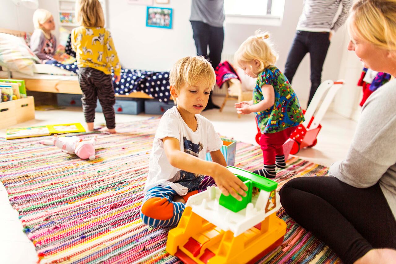 Profesora enseñando a estudiantes en los primeros años.