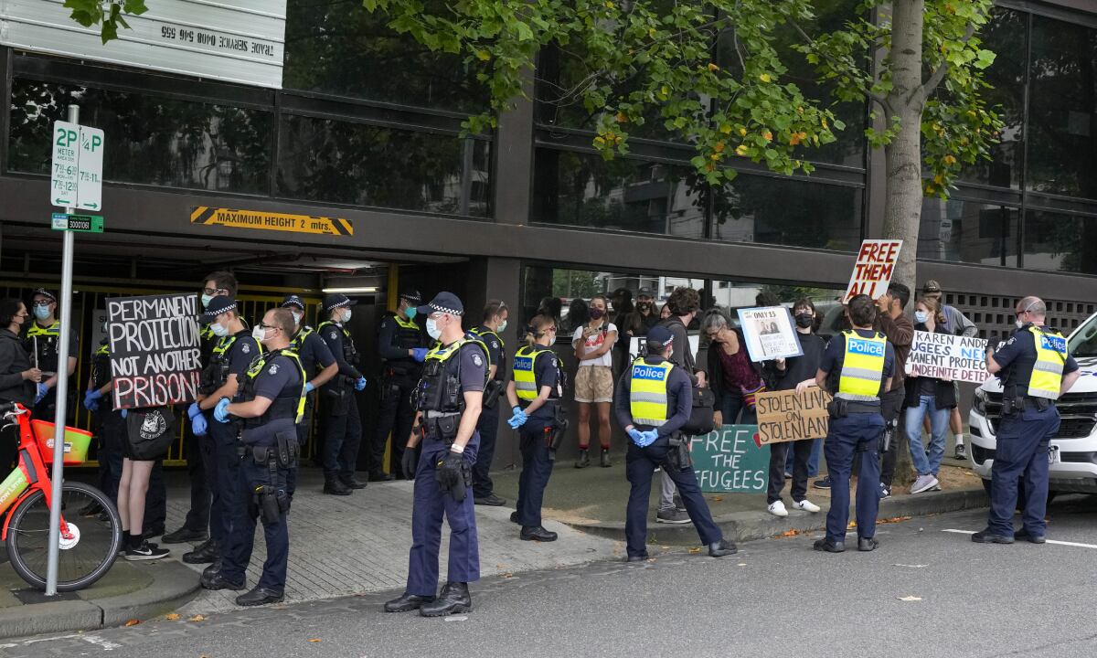 Police surround refugee advocates at the Park Hotel, used as an immigration detention hotel where Serbian tennis player Novak Djokovic is confined in Melbourne, Australia, Monday, Jan. 10, 2022. After five nights in hotel detention Djokovic will get his day in court on Monday in a controversial immigration case that has polarized opinions in the tennis world and elicited heartfelt support for the star back home in his native Serbia. (AP/Mark Baker)