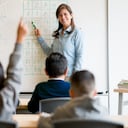 Estudiante en la escuela haciendo una pregunta en clase al maestro - conceptos educativos