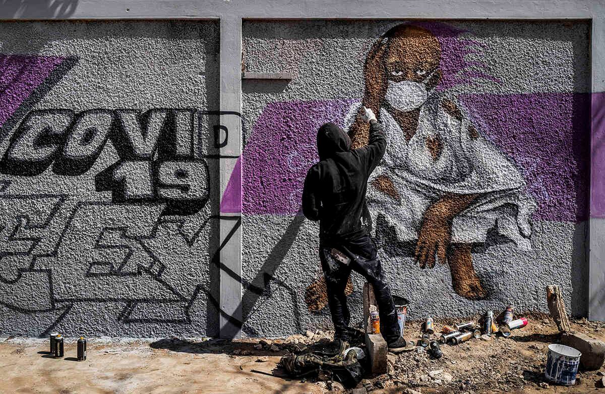 Un miembro del colectivo senegalés de grafiti "RBS CREW" pinta murales informativos que aconsejan cómo detener la propagación del nuevo coronavirus, en la pared de una escuela secundaria en el barrio de Parcelles Assainies de la capital Dakar, Senegal miércoles. Las medidas que se han tomado a nivel mundial incluyen la cuarentena, el lavado de manos de forma frecuente y el uso de tapabocas si existe algún síntoma. Foto: Sylvain Cherkaoui/ AP.