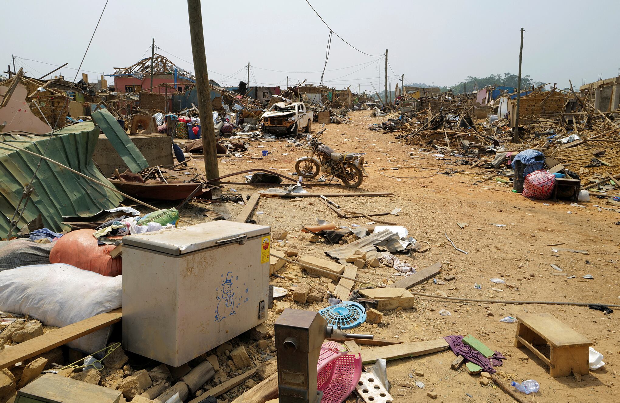 La gente observa los daños causados cuando un vehículo que transportaba explosivos mineros detonó a lo largo de una carretera en Apiate, Ghana. Foto REUTERS/Francis Kokoroko