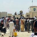 Afghan security guards stand on a wall as hundreds of people gather outside the international airport in Kabul, Afghanistan, Tuesday, Aug. 17, 2021. The Taliban declared an “amnesty” across Afghanistan and urged women to join their government Tuesday, seeking to convince a wary population that they have changed a day after deadly chaos gripped the main airport as desperate crowds tried to flee the country. (AP Photo)