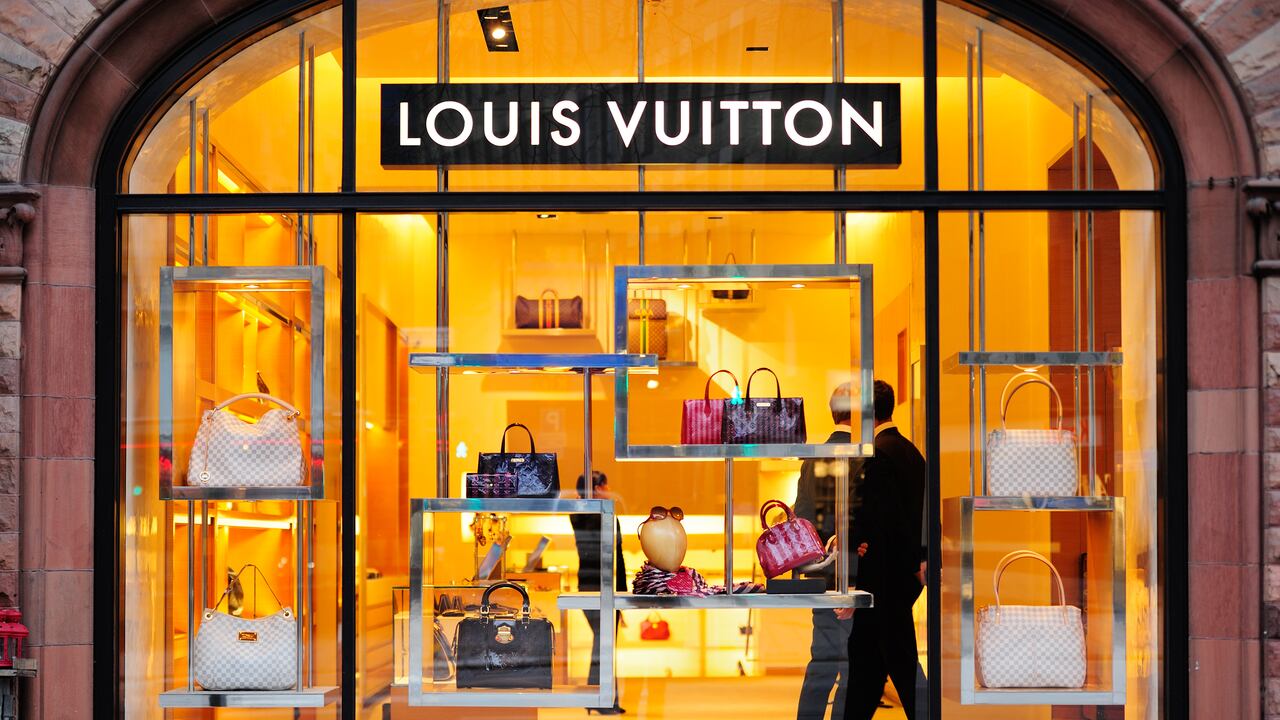 Tienda Louis Vuitton con clientes.