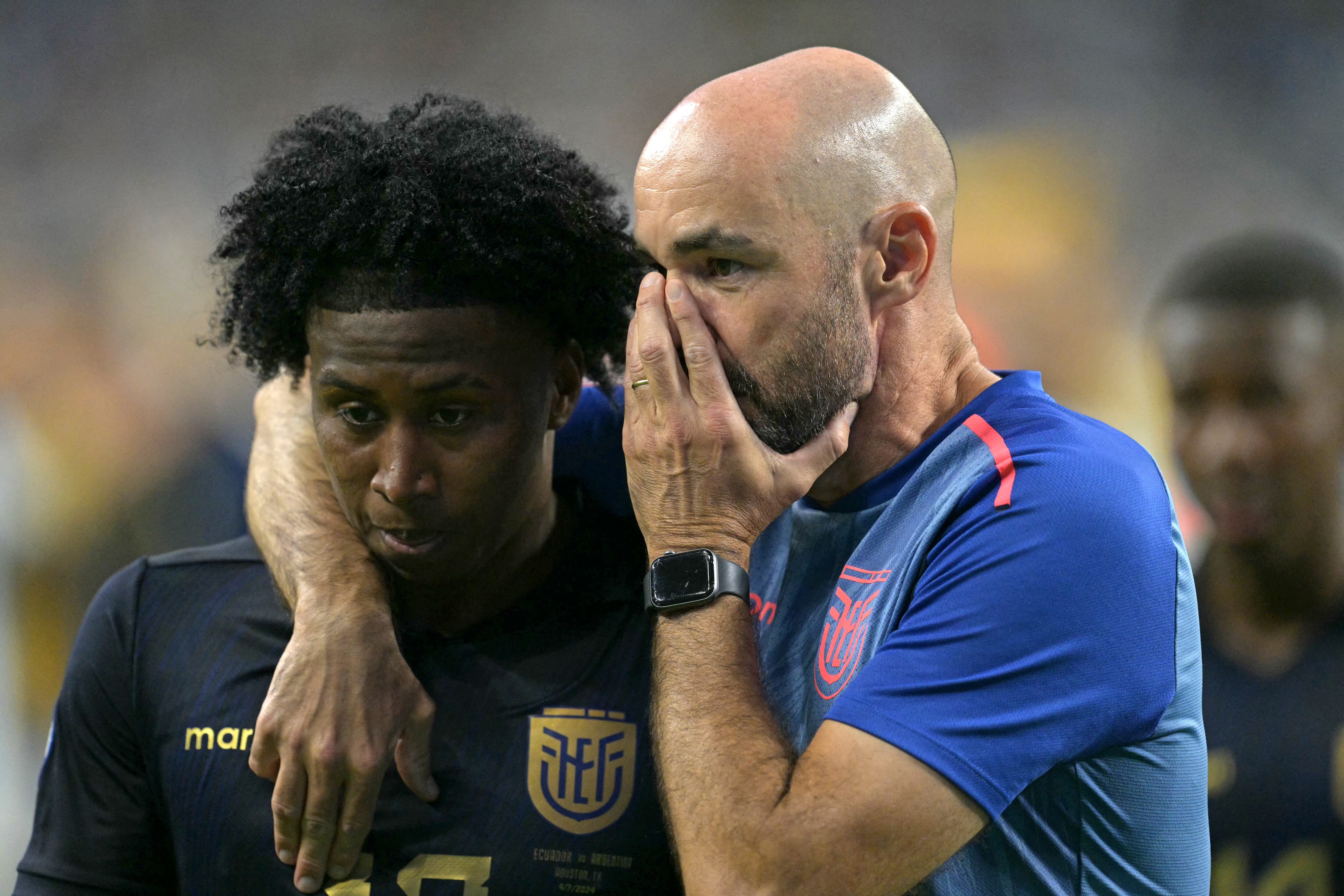 Ecuador's Spanish coach Felix Sanchez (R) chats with Ecuador's defender #17 Angelo Preciado following their team's defeat in the Conmebol 2024 Copa America tournament quarter-final football match between Argentina and Ecuador at NRG Stadium in Houston, Texas, on July 4, 2024. (Photo by JUAN MABROMATA / AFP)