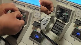 Imagen de referencia de persona desmontando piezas falsas de un cajero automático.
