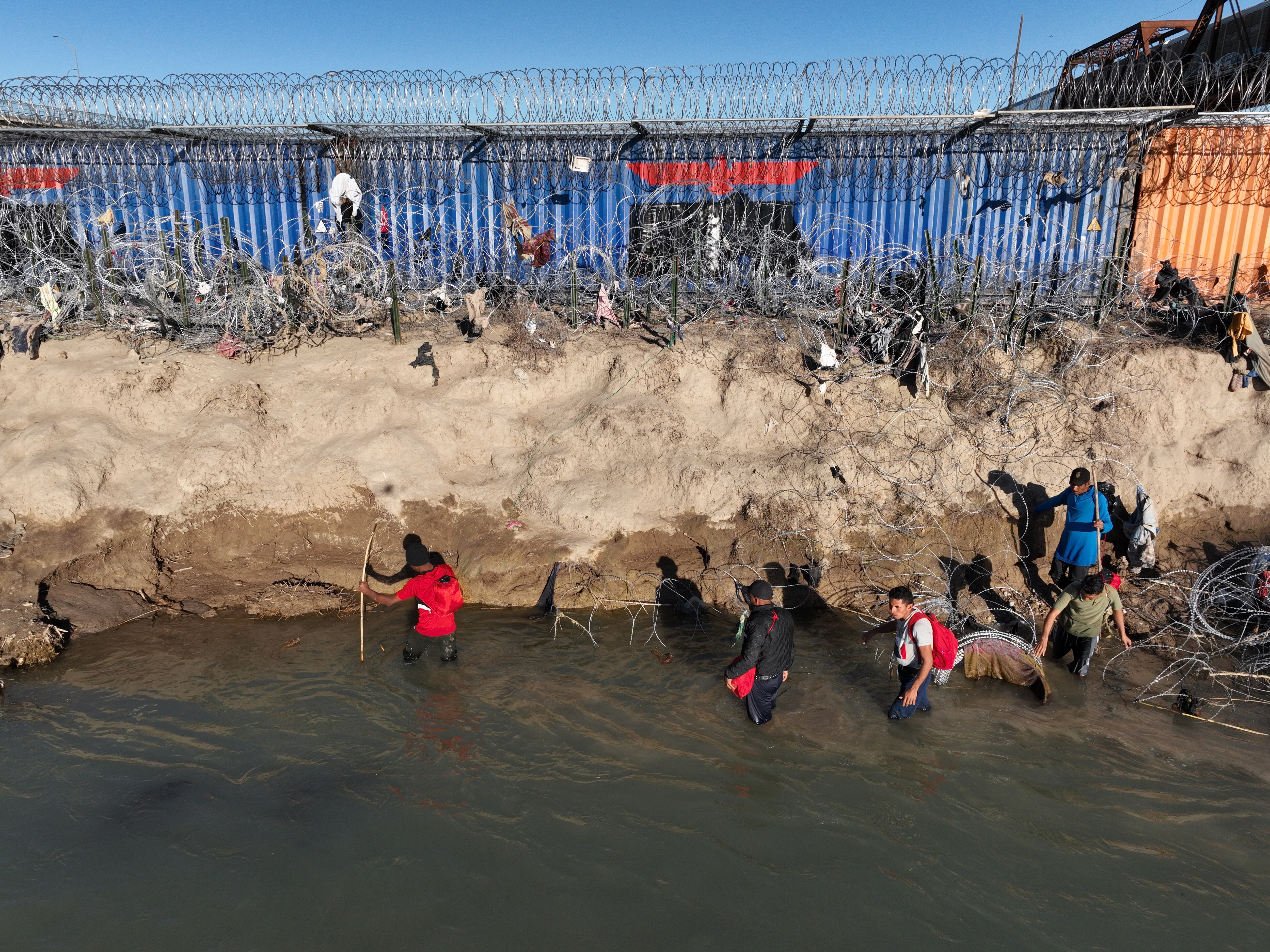 Una vista aérea muestra a un grupo de inmigrantes tratando de cruzar la frontera de Texas a pesar de las medidas de seguridad reforzadas en Eagle Pass, Texas, el 3 de febrero de 2024. La Patrulla Fronteriza alejó a los migrantes de la frontera de Eagle Pass entre Estados Unidos y México como medida cautelar. (Foto de Lokman Vural Elibol/Anadolu vía Getty Images)