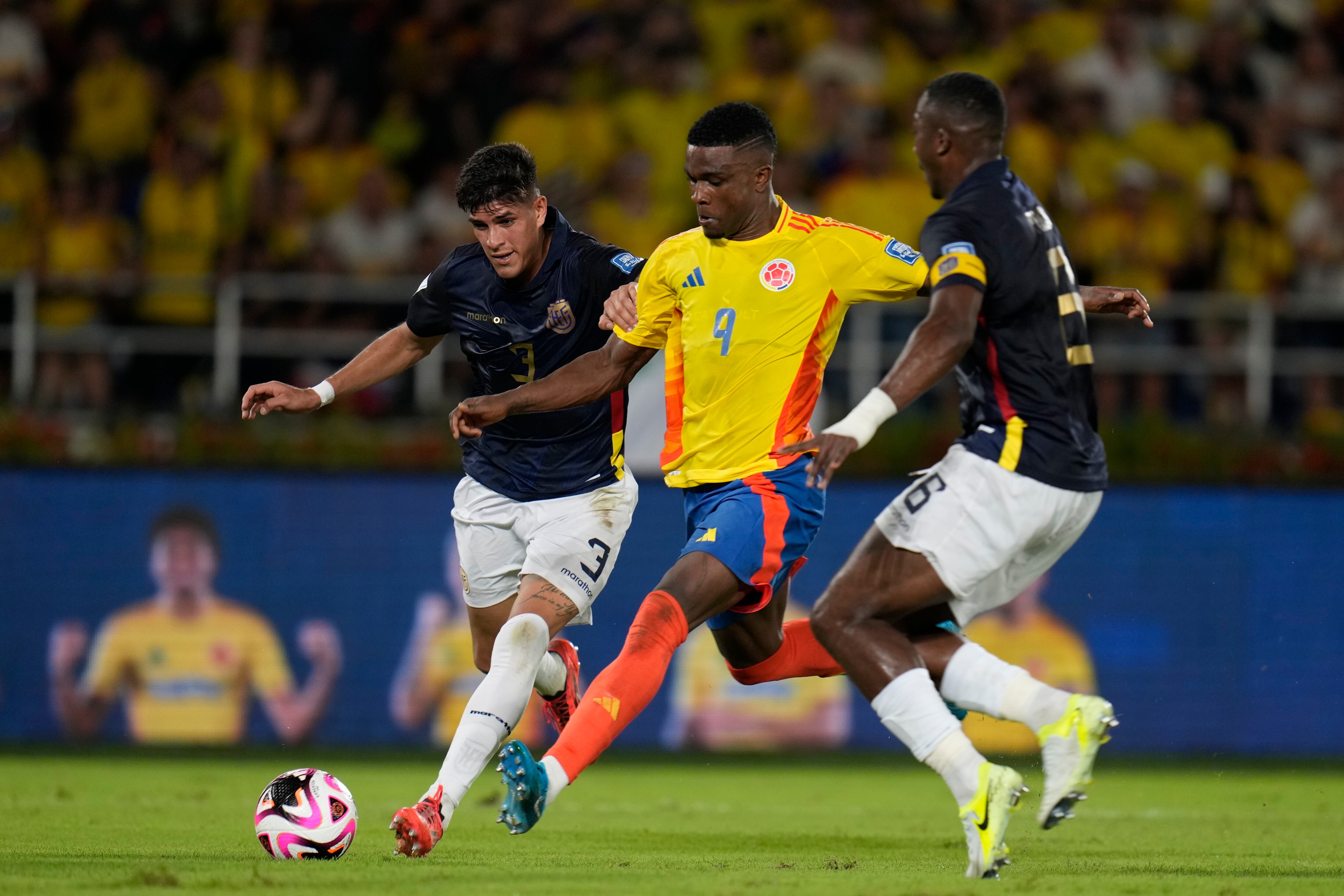 El colombiano Jhon Córdoba (centro), el ecuatoriano Piero Hincapié (izquierda) y Willian Pacho luchan por el balón durante un partido de clasificación para la Copa Mundial de la FIFA 2026 en el estadio Metropolitano Roberto Meléndez en Barranquilla, Colombia, el martes 19 de noviembre de 2024. (Foto AP/Fernando Vergara)