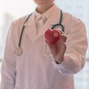 Médico cardiólogo con corazón rojo en el hospital clínico por concepto de atención médica