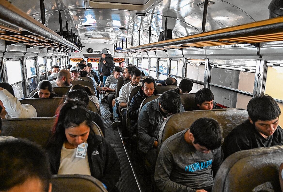 Migrantes guatemaltecos deportados de Estados Unidos abordan un autobús a su llegada a la Base de la Fuerza Aérea de Guatemala en la Ciudad de Guatemala