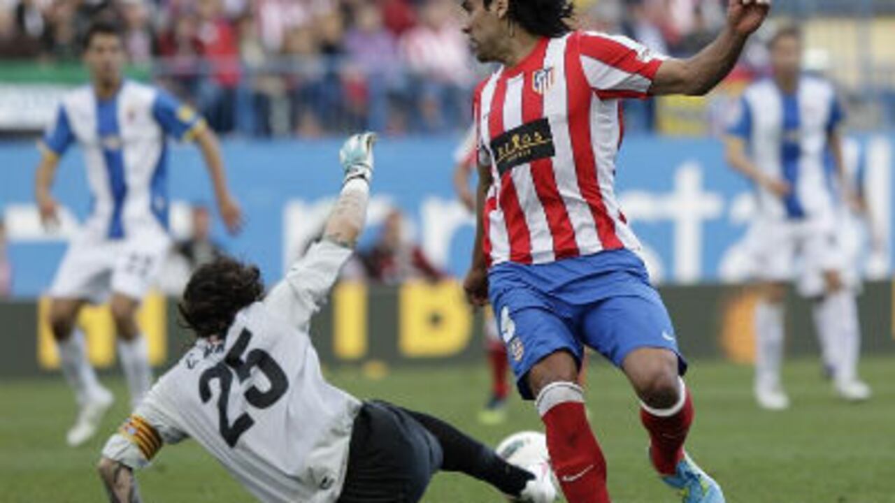 El delantero colombiano del Atlético de Madrid Radamel Falcao observa como el portero del RCD Espanyol Cristian Álvarez detiene un ataque de su equipo durante el partido que ambas escuadras sostuvieron el domingo en el estadio Vicente Calderón.