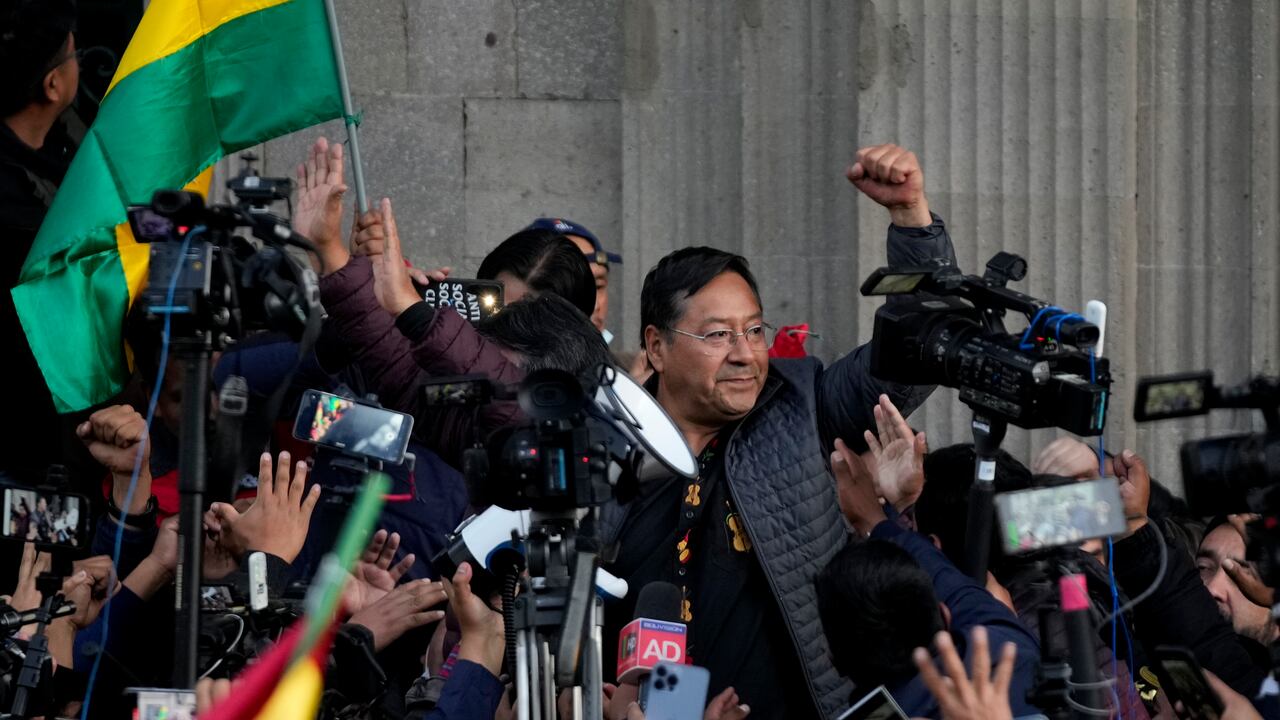 El presidente boliviano Luis Arce levanta un puño cerrado rodeado de partidarios y medios de comunicación frente al palacio de gobierno en La Paz, Bolivia, el miércoles 26 de junio de 2024. (AP Foto/Juan Karita)