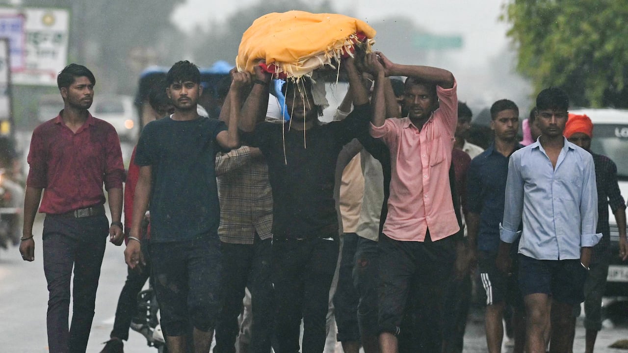 Hombres cargan el cuerpo de una víctima que murió en una estampida durante un sermón en Hathras, en el estado indio de Uttar Pradesh, en Kasganj el 3 de julio de 2024. Los supervivientes de la estampida más mortífera de la India en más de una década recordaron el 3 de julio el horror de ser aplastados. en una reunión religiosa hindú muy superpoblada donde murieron 121 personas. (Photo by Arun SANKAR / AFP)