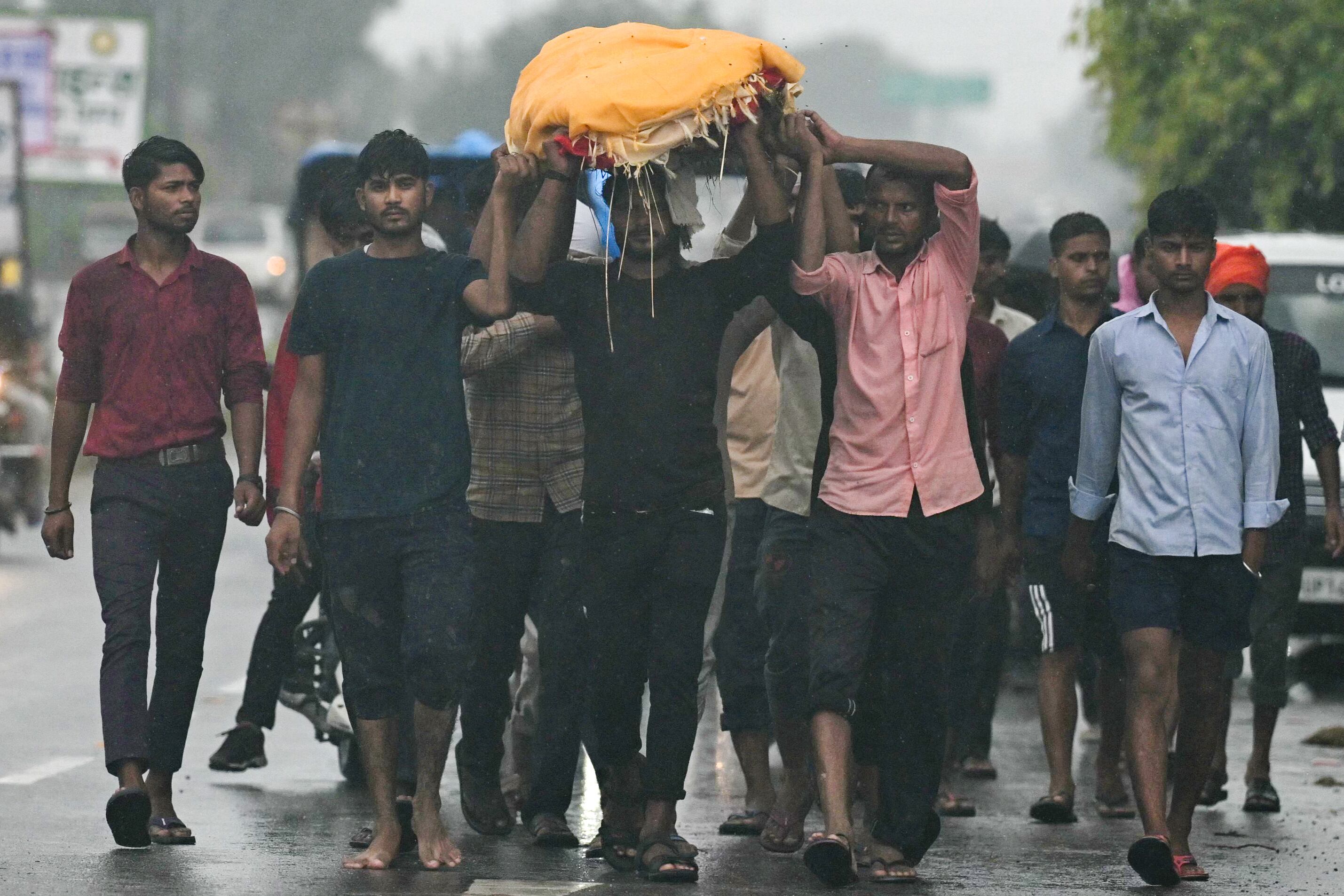Hombres cargan el cuerpo de una víctima que murió en una estampida durante un sermón en Hathras, en el estado indio de Uttar Pradesh, en Kasganj el 3 de julio de 2024. Los supervivientes de la estampida más mortífera de la India en más de una década recordaron el 3 de julio el horror de ser aplastados. en una reunión religiosa hindú muy superpoblada donde murieron 121 personas. (Photo by Arun SANKAR / AFP)