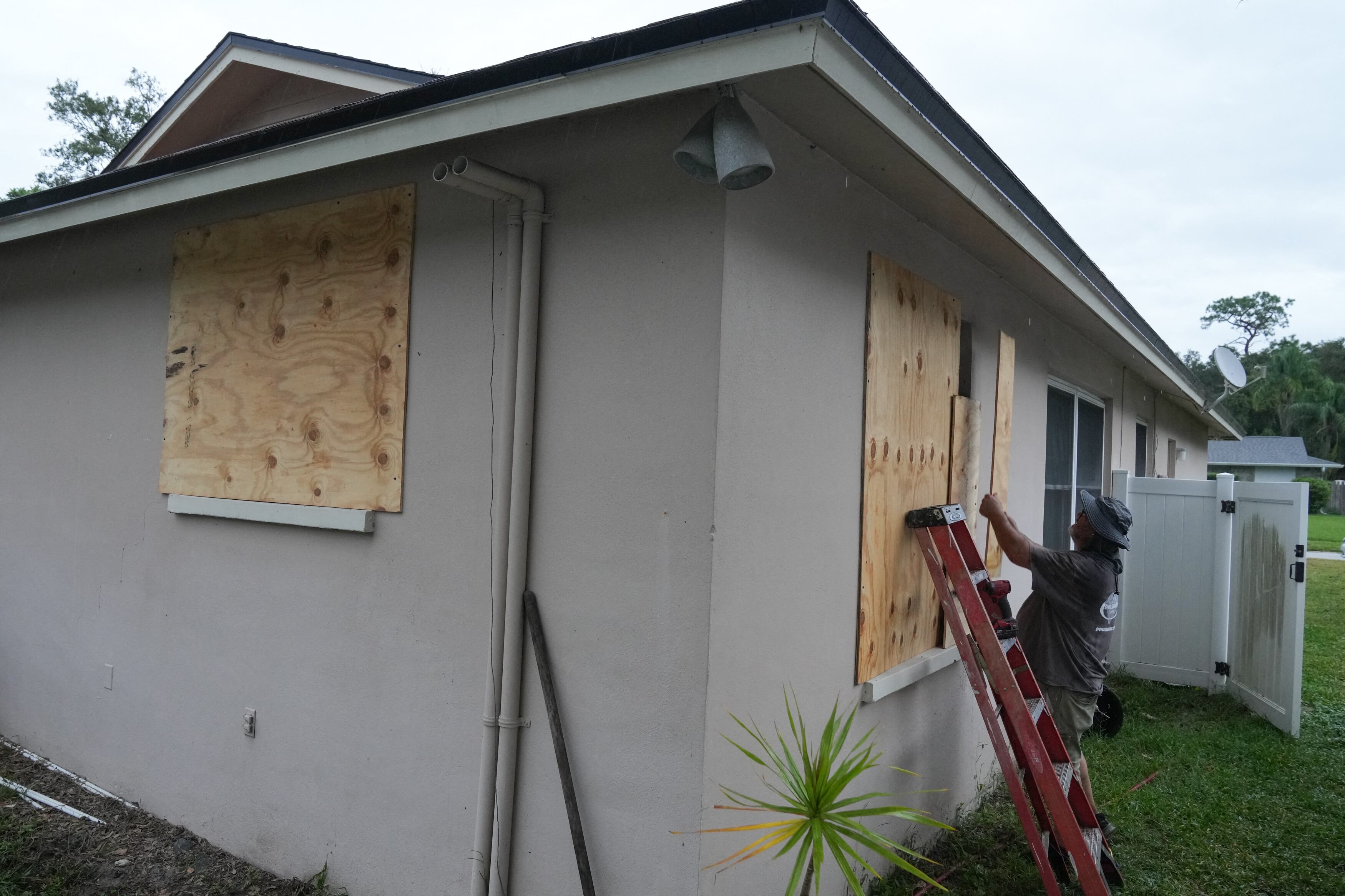 Un residente tapa sus ventanas con tablas en Palm Harbor, Florida, antes de la llegada prevista del huracán Milton a mitad de semana el 6 de octubre de 2024. Otra tormenta potencialmente devastadora azotó la costa de Florida el 6 de octubre