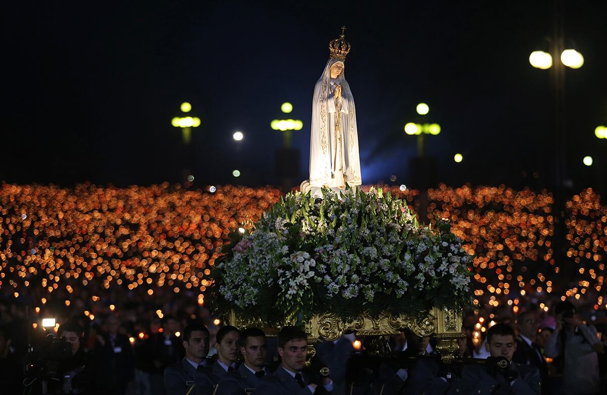 Una estatua de Nuestra Señora de Fátima es cargada durante una vigilia en el santuario de Nuestra Señora de Fátima en Portugal. (AP/Francisco Seco)