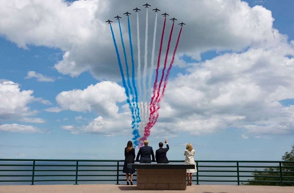 6 de junio - Emmanuel Macron y su esposa Brigitte Macron observan los aviones que dejan a su paso la bandera francesa pintada en el cielo. El presidente Donald Trump y la primera dama de los EE. UU. Melania Trump, los acompañan. Fotógrafo: Ian Langsdon /AP