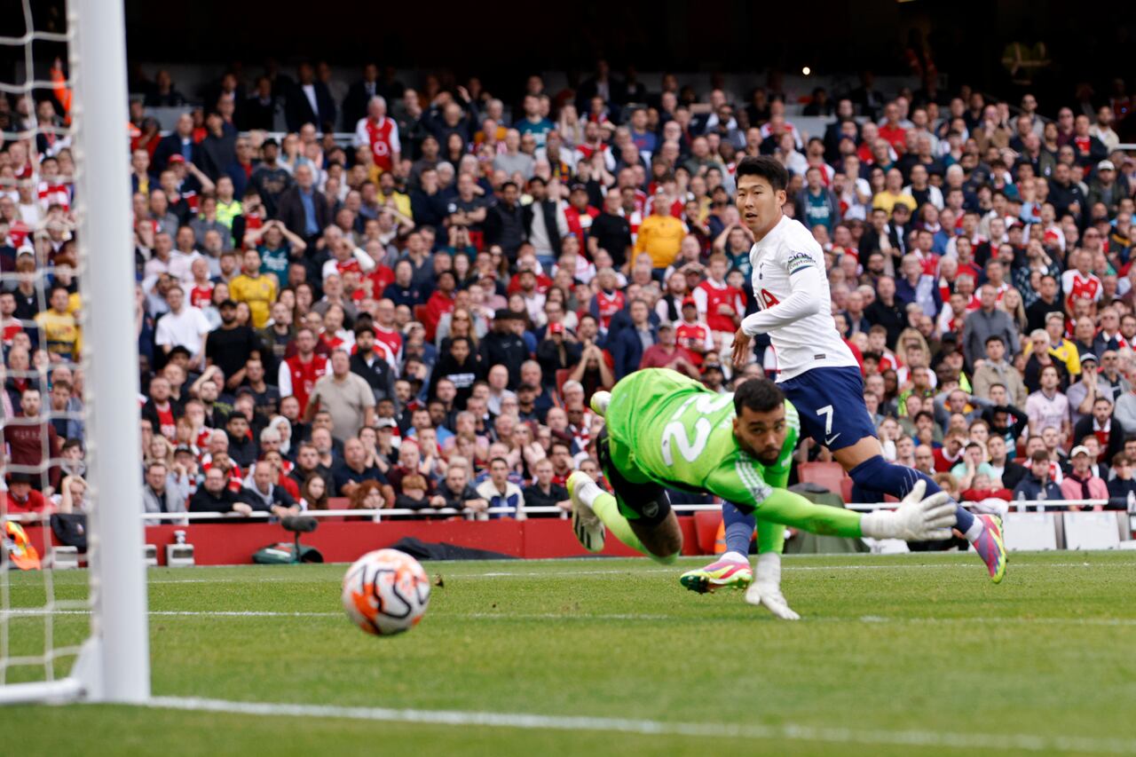 Son Heung-min del Tottenham anota el segundo gol de su equipo superando al portero del Arsenal David Raya durante el partido de fútbol de la Liga Premier inglesa entre Arsenal y Tottenham Hotspur en el estadio Emirates de Londres, Inglaterra, el domingo 24 de septiembre de 2023. (Foto AP/David Cliff)