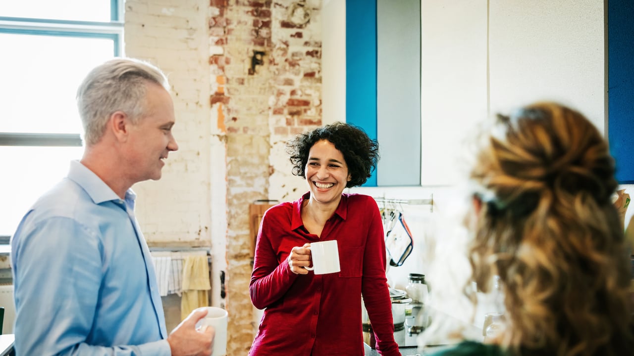 Un grupo de compañeros se toma un descanso del trabajo para tomar un café juntos en la oficina.