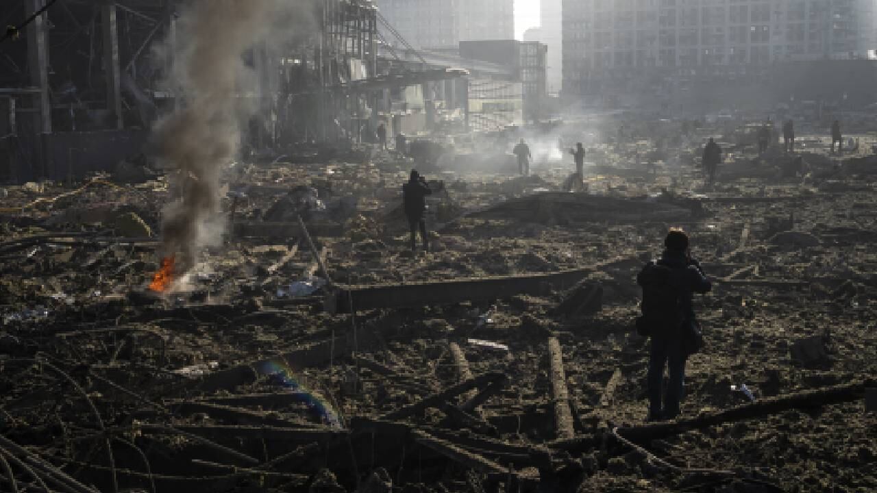Gente reunida entre los restos de un ataque a un centro comercial en Kiev, Ucrania, el lunes 21 de marzo de 2022. (AP Foto/ (AP Foto/Rodrigo Abd)