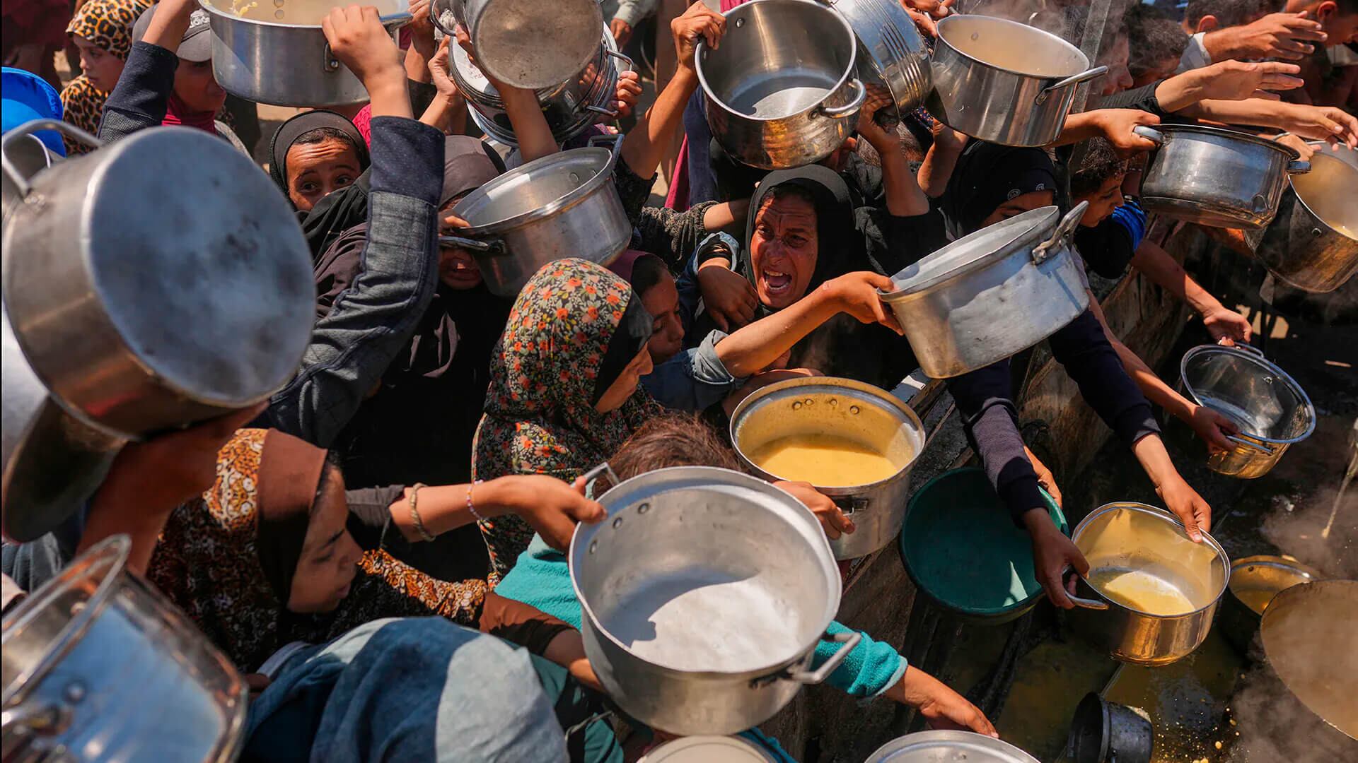 Los palestinos luchan por conseguir comida donada en una cocina comunitaria en la ciudad de Gaza, al norte de la Franja de Gaza, el lunes, 4 de agosto de 2025.
