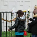 People lay flowers just in front of the ground floor flat where the bodies of a woman and her four children where discovered, in Meaux, eastern Paris, on December 26, 2023. French police arrested, the father, suspected of murdering his wife and their four children aged nine months, four, seven and 10 years old, opening an enquiry into their "premeditated murder", in Meaux, eastern Paris, on December 26, 2023. (Photo by ALAIN JOCARD / AFP)