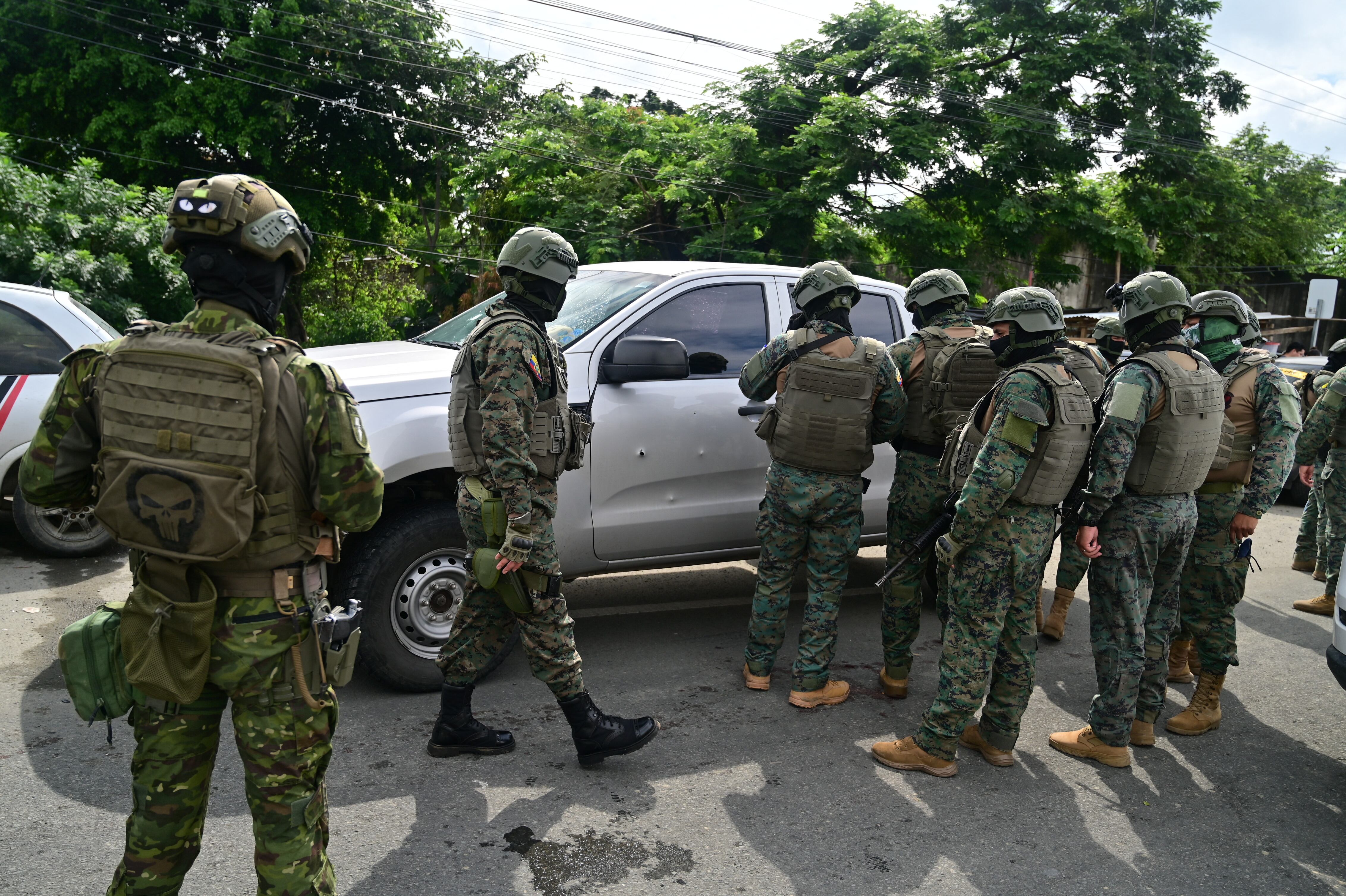 Military officers inspect the pickup truck in which a colonel of the Ecuadorian Armed Forces was murdered in Guayaquil, Ecuador, on February 14, 2025. A colonel of Ecuador's Armed Forces was shot dead on Friday near the Litoral Penitentiary in Guayaquil (southwest), in a country plunged into drug violence, police said. (Photo by MARCOS PIN / AFP)