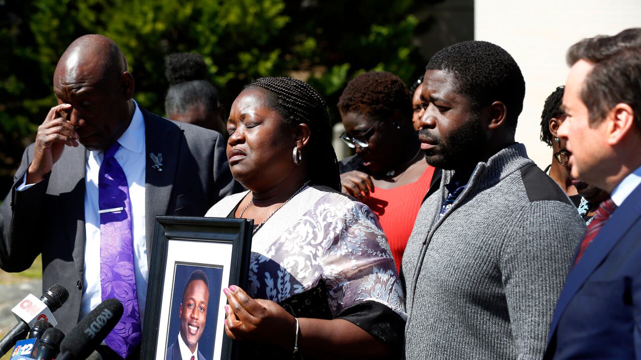 Caroline Ouko, madre de Irvo Otieno, muestra un retrato de su hijo acompañada del abogado Ben Crump, a la izquierda, su hijo mayor, Leon Ochieng, y el abogado Mark Krudys, en la Corte de Dinwiddie, en Dinwiddie, Virginia, el jueves 16 de marzo de 2023. (Daniel Sangjib Min/Richmond Times-Dispatch vía AP)