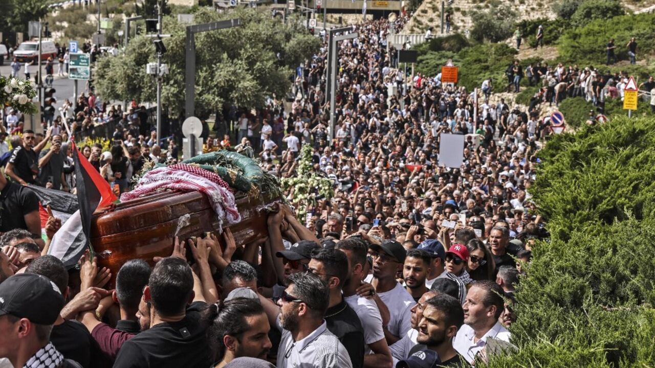 Los dolientes palestinos llevan el ataúd de la periodista de Al-Jazeera asesinada Shireen Abu Akleh desde una iglesia hacia el cementerio, durante su cortejo fúnebre en Jerusalén, el 13 de mayo de 2022. -Abu Akleh, quien fue asesinado a tiros el 11 de mayo de 2022 mientras cubría un incursión en la Cisjordania ocupada por Israel, fue una de las figuras más destacadas de los medios árabes y fue ampliamente aclamada por su valentía y profesionalismo. (Foto de RONALDO SCHEMIDT / AFP)