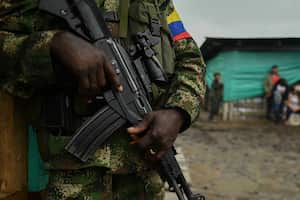 A FARC-EP dissident stands guard during a meeting with local communities in San Vicente del Caguan, Caqueta department, Colombia, on April 16, 2023. - An armed dissident group of Colombia's disbanded FARC guerrillas said Sunday it was "ready" to start peace talks with the government from May 16. "We are announcing to the world that our delegates to the dialogue table with the Colombian government... are ready for May 16," the EMC dissident grouping, which rejected a 2016 peace deal that disarmed the FARC, said through a spokesperson. (Photo by JOAQUIN SARMIENTO / AFP)