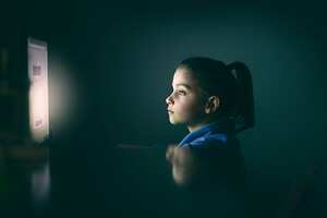 girl using computer at night