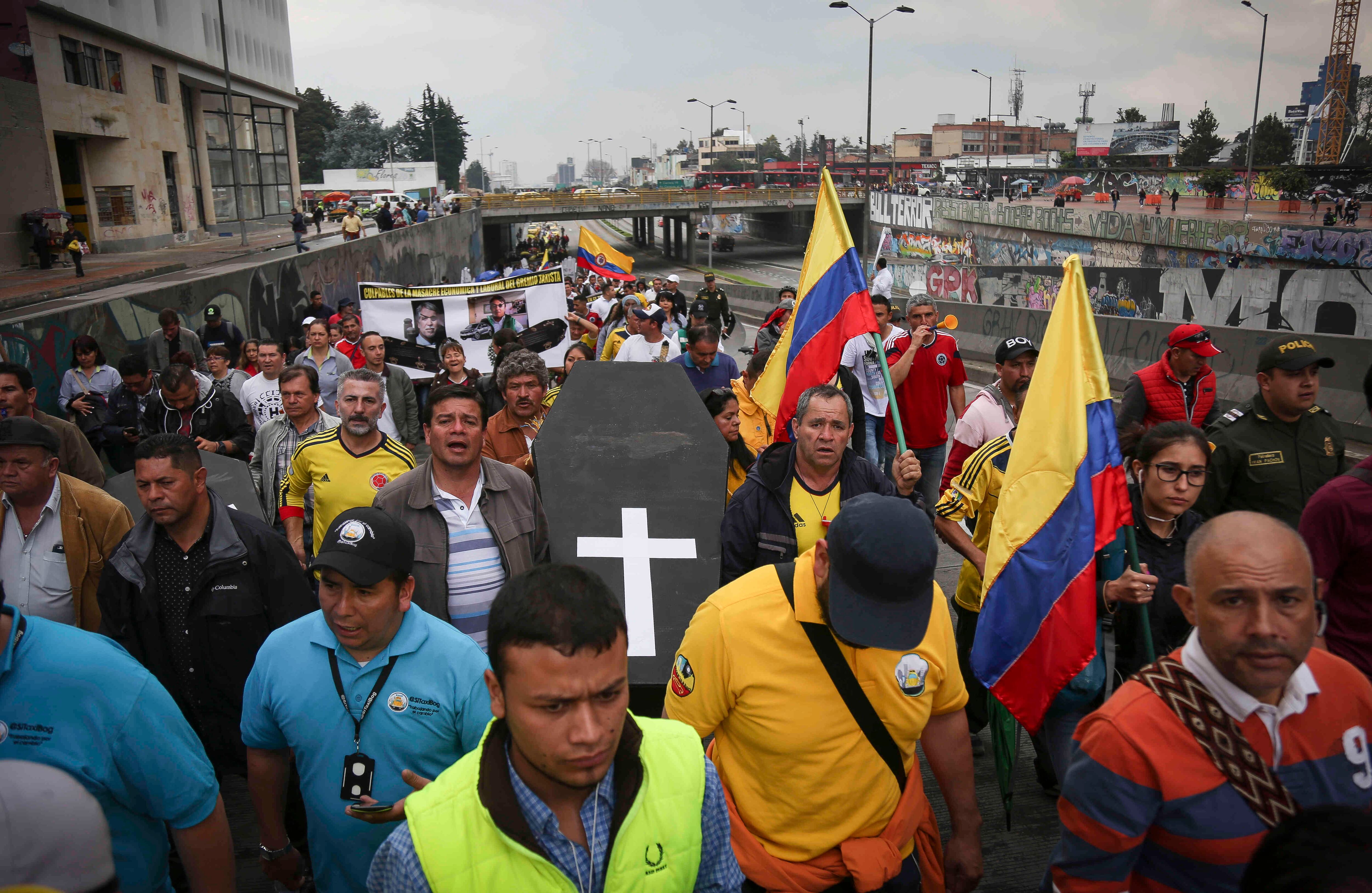 Conductores cargan un falso ataúd para pedir que la plataforma Uber se acabe. Esteban Vega La-Rotta / Semana
