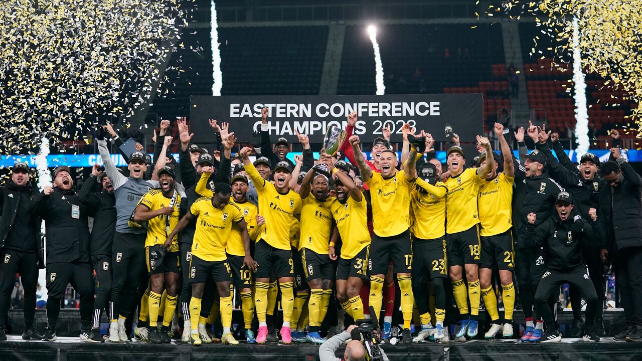 El mediocampista del Columbus Crew, Darlington Nagbe (6), sostiene el trofeo mientras celebra con sus compañeros de equipo después del partido final de fútbol de la Conferencia Este de la MLS contra el FC Cincinnati, el sábado 2 de diciembre de 2023, en Cincinnati. Colón ganó 3-2 en tiempo extra. También se ven a Diego Rossi (10), Cucho Hernández (9), el defensa del Columbus Crew Steven Moreira (31), Christian Ramirez (17), Patrick Schulte (28), Malte Amundsen (18) y Yevhen Cheberko (21). . (Foto AP/Carolyn Kaster)