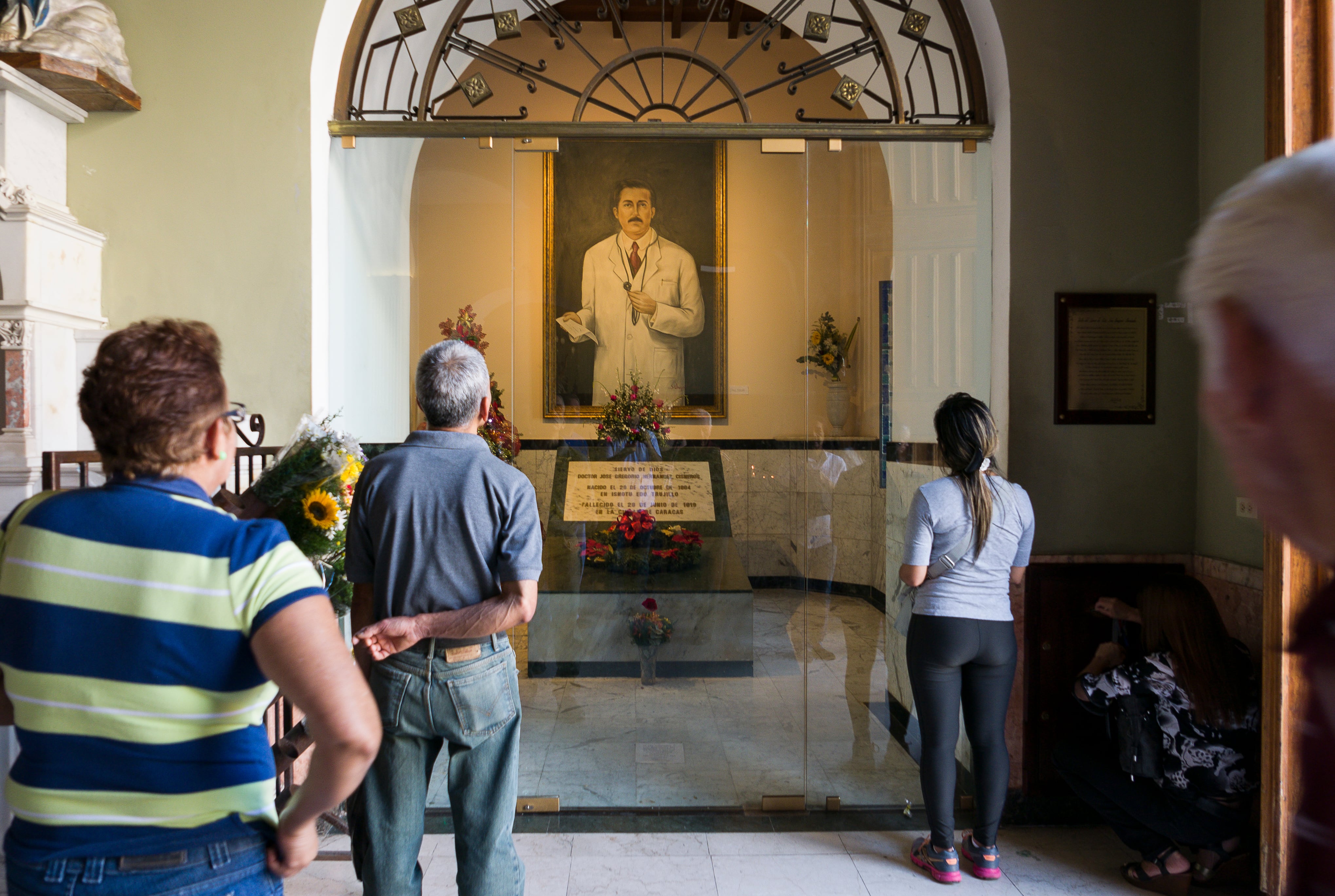 Los creyentes se paran frente a una pintura del Dr. José Gregorio Hernández (26 de octubre de 1864 - 29 de junio de 1919), médico venezolano, en la iglesia de Nuestra Señora de Candelaria el 4 de enero de 2017 en Caracas, Venezuela. La leyenda del Doctor José Gregorio Hernández (MD, OFS) comenzó a afirmar que se le habían concedido milagros luego de orar por su intercesión a Dios. También es venerado por la religión alternativa y sincrética de Venezuela, el Culto a María Lionza. (Foto de Thierry Monasse/Corbis vía Getty Images)
