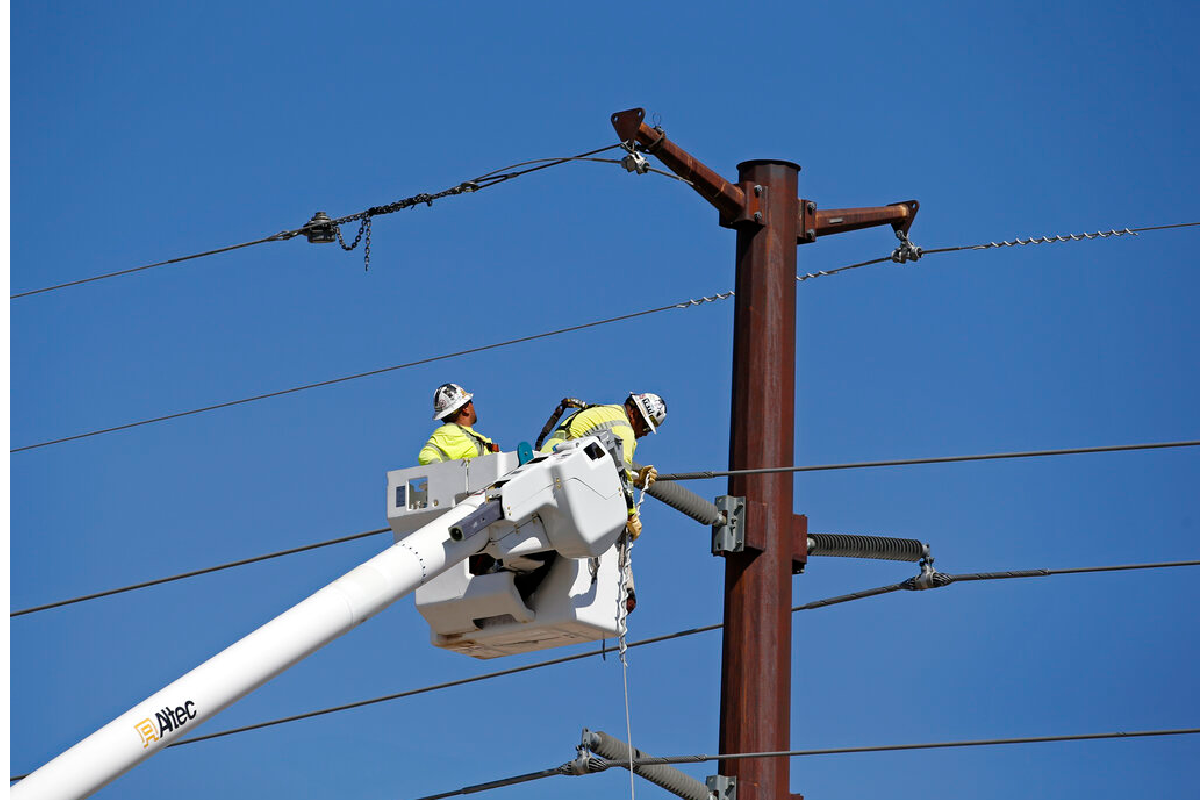 Los trabajadores reparan una línea eléctrica cercana al sitio del accidente.