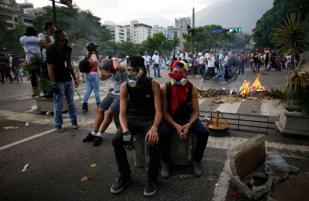 Los manifestantes anti-gobierno descansan durante una ruptura en los enfrentamientos con las fuerzas de seguridad en Caracas, Venezuela, el miércoles 19 de abril de 2017. Decenas de miles de opositores al presidente Nicolás Maduro inundaron las calles de Caracas en lo que se ha apodado la " Todas las marchas "contra el presionado presidente. (Foto AP / Ariana Cubillos)
