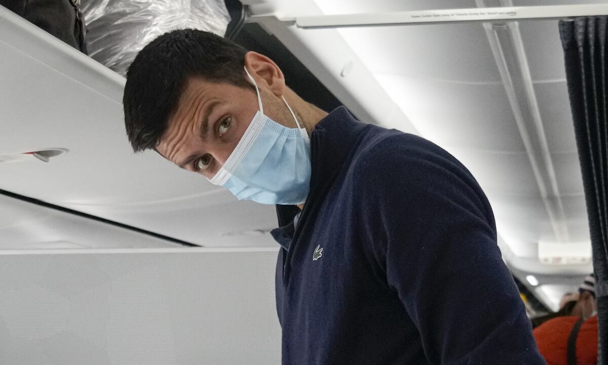Novak Djokovic se prepara para ocupar su asiento en un avión a Belgrado, en Dubái, Emiratos Árabes Unidos, el lunes 17 de enero de 2022. Djokovic fue deportado de Australia el domingo tras perder una batalla legal para quedarse en el país para defender su título del Abierto de Australia pese a no haberse vacunado contra el COVID-19. (AP/Darko Bandic)