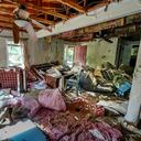 Cindy White observa la devastación dentro de su casa causada por el huracán Helene, el martes 1 de octubre de 2024 en Morganton, Carolina del Norte. El río Catawba adyacente se inundó debido a las lluvias torrenciales que destruyeron siete de las nueve casas de la familia en la propiedad. (Foto AP/Kathy Kmonicek)