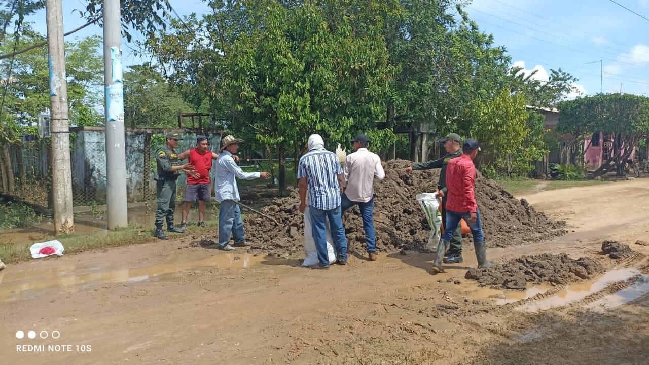 Las personas llenan sacos con arena para crear muros que evite la inundación en más zonas por la creciente del río Magdalena.