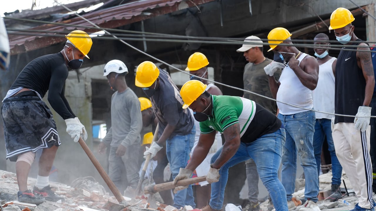 Trabajadores tratan de rescatar a personas en los escombros de edificaciones colapsadas tras el terremoto de este lunes con epicentro en Chocó.