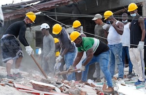 Trabajadores tratan de rescatar a personas en los escombros de edificaciones colapsadas tras el terremoto de este lunes con epicentro en Chocó..