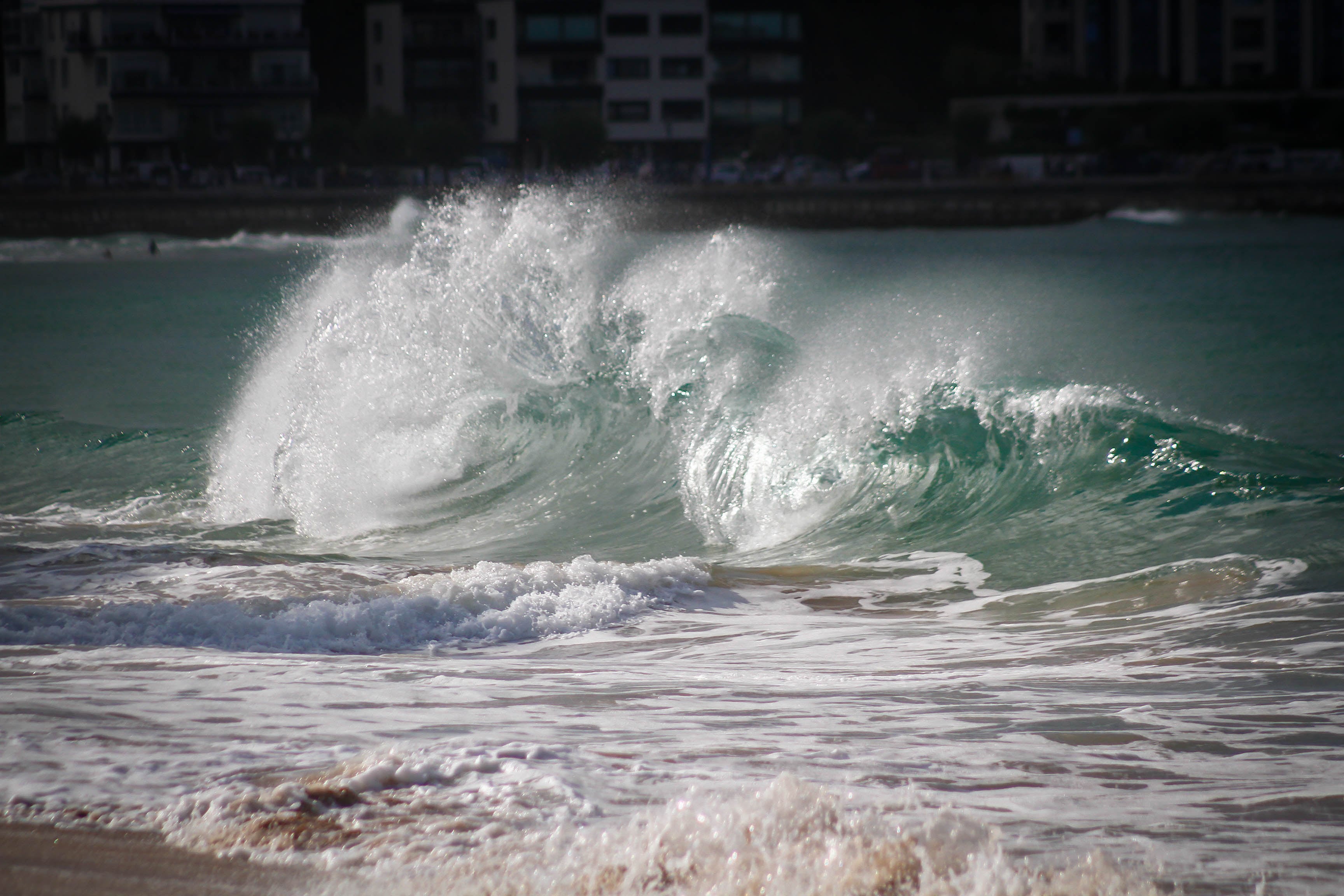 Ola rompiendo en la orilla de la playa.
