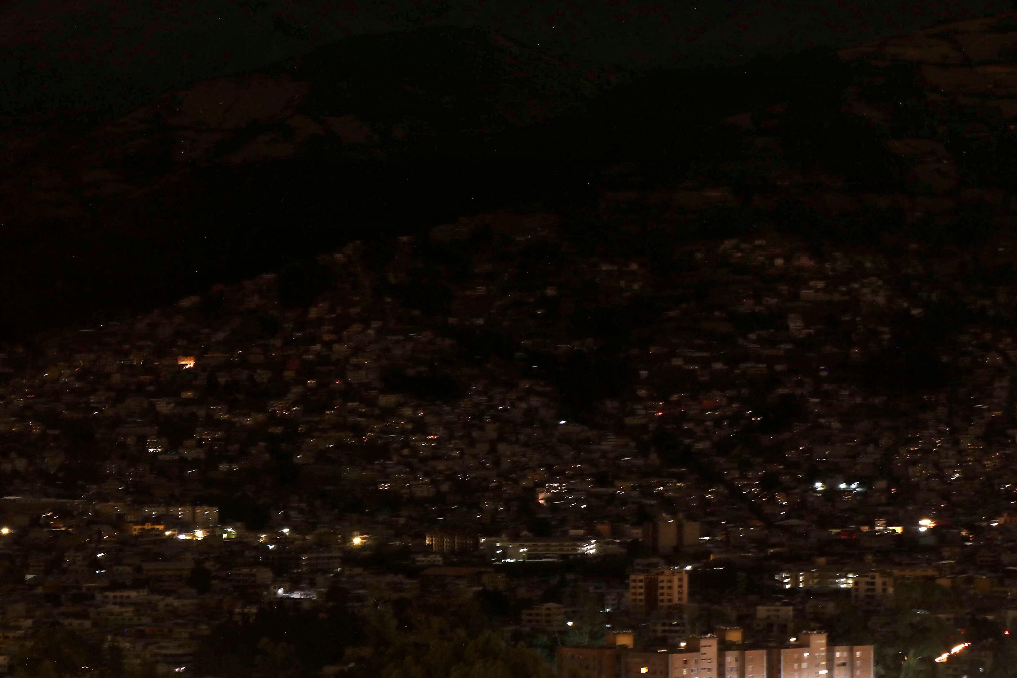 Vista parcial de la ciudad en oscuridad durante un racionamiento nacional programado de electricidad debido al mantenimiento del sistema de transmisión y redes de distribución, en Quito el 18 de septiembre de 2024. Ecuador estará en oscuridad el miércoles por la noche debido a un apagón programado de ocho horas en en medio de una crisis energética resultante de la peor sequía en 60 años. (Foto de Galo Paguay / AFP)