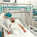 Los médicos con trajes de protección, gafas y máscaras están monitoreando el estado de un paciente con enfermedad por coronavirus covid-19 en la unidad de cuidados intensivos. Tratamiento durante una pandemia en una clínica moderna.