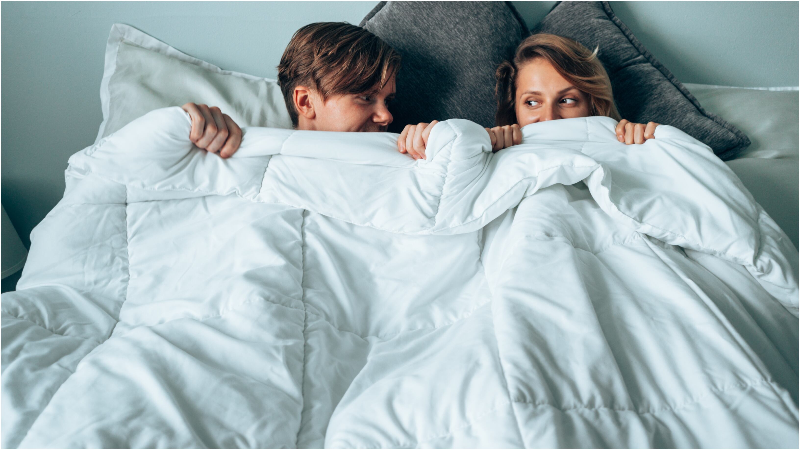 Pareja metida entre las cobijas