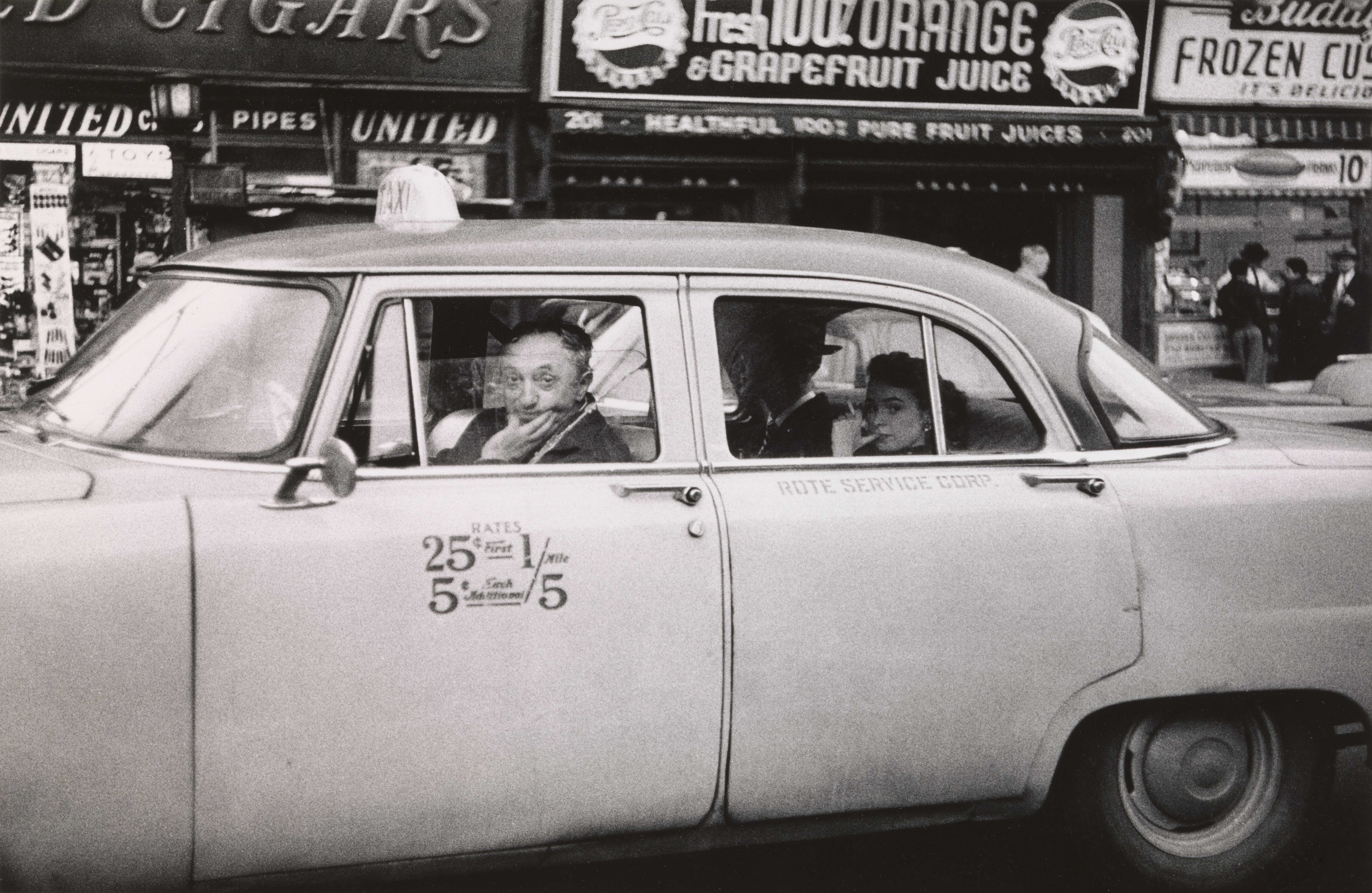 Taxicab driver at the wheel with two passengers, N.Y.C. 1956. © The Estate of Diane Arbus, LLC. All Rights Reserved.