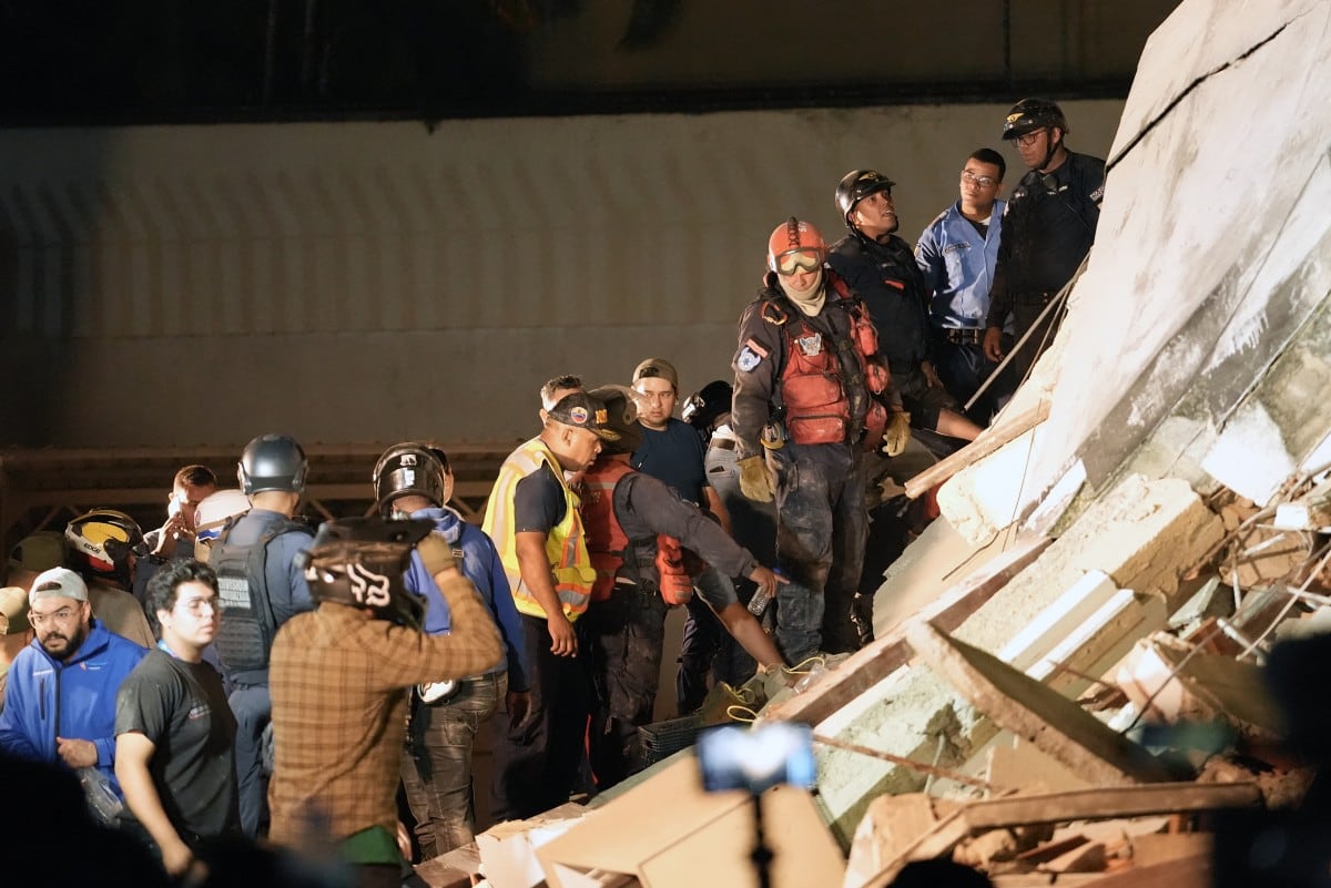 Los rescatistas trabajan entre los restos de un edificio derrumbado tras el terremoto que sacudió Caracas.