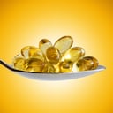 Omega-3 pills on spoon.