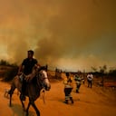 A resident flees an encroaching forest fire in Vina del Mar, Chile, Saturday, Feb. 3, 2024. Officials say intense forest fires burning around a densely populated area of central Chile have left several people dead and destroyed hundreds of homes. (AP Photo/ Esteban Felix)