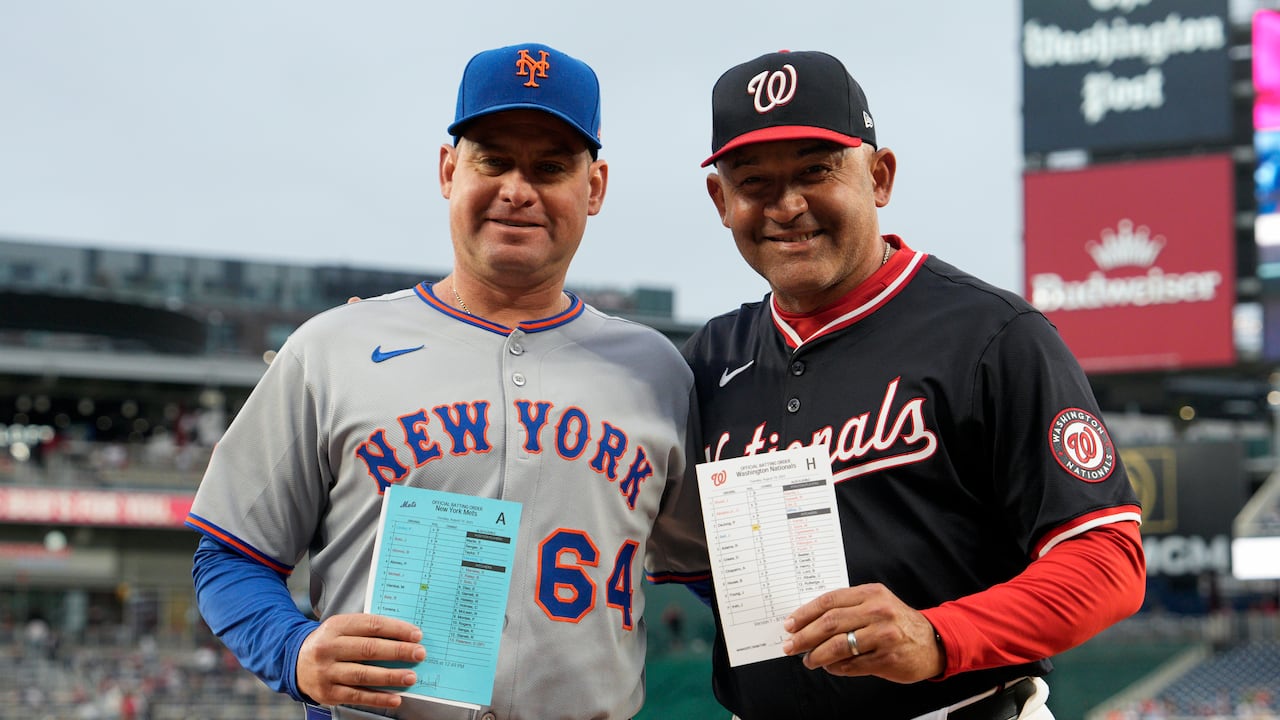 WASHINGTON, DC - AUGUST 19: Managers Carlos Mendoza #64 of the New York Mets and Miguel Cairo #22 of the Washington Nationals pose for a photo after delivering the lineup cards before a game at Nationals Park on August 19, 2025 in Washington, DC. This marks the first game in Major League history to feature two Venezuelan-born managers. (Photo by Jess Rapfogel/Getty Images)
